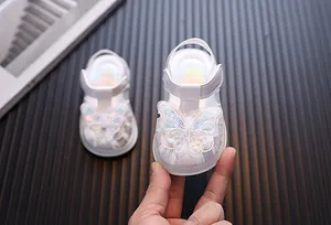 Detailed view of white girl's princess sandals with sequined butterfly and light-up soles