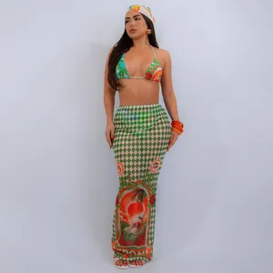 Stylish sexy three-piece bikini set featuring a matching printed mesh beach maxi skirt