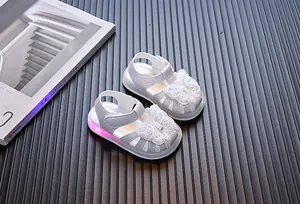 Detail of toddler girl silver sandals with light-up soles and butterfly embroidery