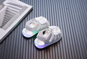 Detail showing white toddler sandals with butterfly ornaments and LED light-up soles