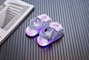 Close-up view of baby girl sandals featuring LED light-up soles and butterfly embroidery