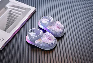 Close-up of toddler girls' purple sandals featuring a glowing LED sole and butterfly applique.