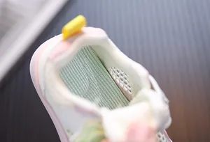 Macro detail showing the breathable mesh interior lining of pink toddlers' walking shoes