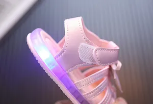 Detailaufnahme der rosa Mädchensandale mit leuchtenden LED-Lichtern in der Sohle