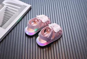 Toddler girl butterfly sandals with LED light-up soles on a textured background