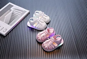 Kleinkinder-Sandalen für Mädchen mit leuchtender LED-Sohle und Schleife in Pink und Weiß.