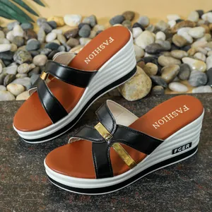 Vista detallada de sandalias de cuña para mujer con tiras negras y detalles dorados