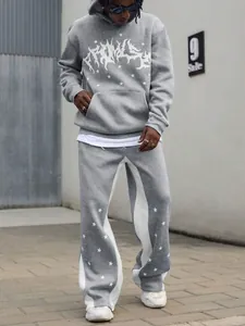 Detail view of men's grey tracksuit with white star patterns and urban graphic print.