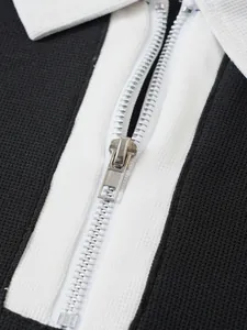 Detaillierte Makroaufnahme des silbernen Reißverschlusses an einem Piqué-Poloshirt