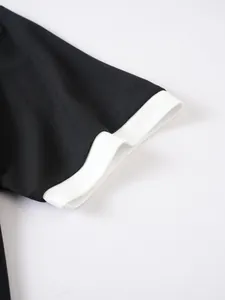 Detailansicht von Piqué-Stoff und Rippbündchen am schwarz-weißen Poloshirt