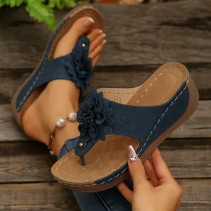 Stylish navy blue wedge sandals for women with elegant flower ornament and open-toe design.