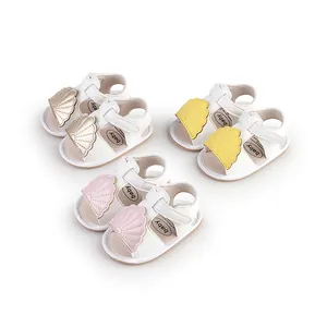 Detailed view of baby summer sandals in pink, yellow, and champagne gold colors