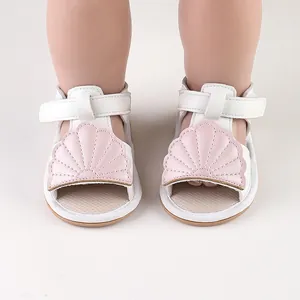 Detailed close-up view of white baby summer sandals featuring a cute pink shell design.