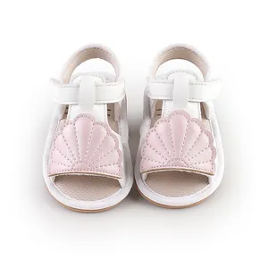 Detail view of baby summer sandals featuring a cute pink shell design on white leather