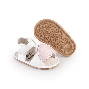 Detailed view of white baby sandals with pink shell motif and non-slip sole