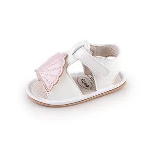 Detail view of a white baby summer sandal featuring a soft pink shell-shaped applique.