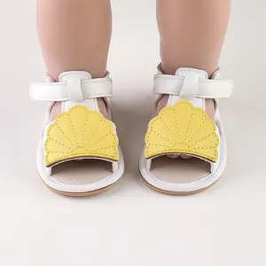 Close-up of baby summer sandals with yellow shell decoration and velcro strap