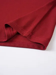 Nahaufnahme eines tiefroten Poloshirts-Saums mit hochwertiger Waffelstruktur und Nähten