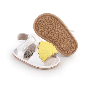 Adorable white baby walking sandals with yellow shell detail and non-slip rubber soles