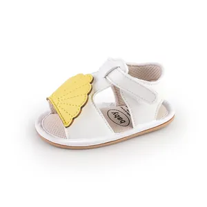 White baby summer sandals with yellow shell detail and velcro strap closure