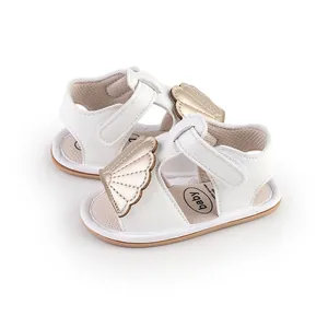 White infant summer sandals with gold wing decoration and hook-and-loop strap fasteners.