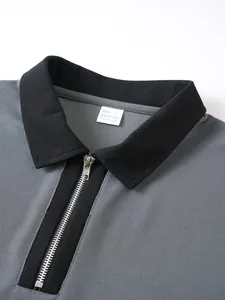 Detailaufnahme eines grauen Herren-Poloshirts mit schwarzem Kragen und halbem Reißverschluss.