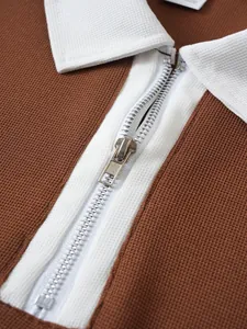 Detailansicht von Reißverschluss und weißem Kragen am braunen Piqué-Poloshirt