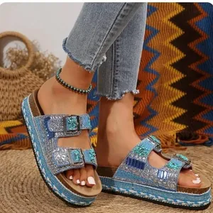 Detailopname van glitterende platform sandalen met strassteentjes en dubbele gespen.