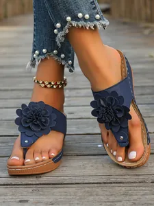 Detailansicht der marineblauen Keilsandalen mit dekorativem Blumenakzent