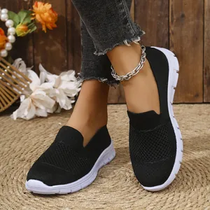 Primer plano de zapatillas de malla negra transpirable para mujer sobre esterilla.