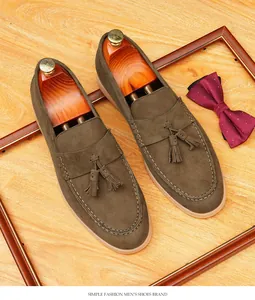 Λεπτομερής όψη καφέ σουέτ loafers με κομψές φούντες και ξύλινα καλαπόδια παπουτσιών.