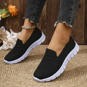 Vista detallada de zapatillas de malla negra transpirable para mujer con suela blanca
