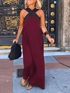 Detail view of a stylish burgundy sleeveless halter maxi dress with a black cross-neck design