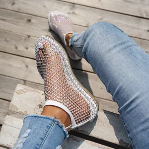 Stivaletti piatti in rete con strass per l'estate abbinati a jeans in denim blu