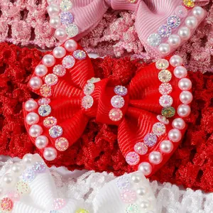 Macro shot of cute red baby bow with pearls and rhinestones for soft sole princess shoes