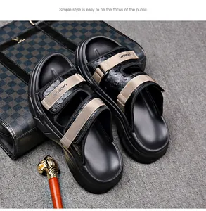 Detail view of black thick-sole sandals with tan adjustable Velcro straps.