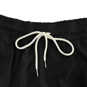 Dettaglio pantaloncini di velluto a coste neri con vita elastica e coulisse bianca