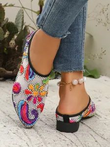 Detailansicht der bunten Blumenstickerei auf atmungsaktiven Mesh-Flachmules für Damen.