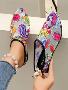Detailansicht von flachen Netzschuhen für Damen mit lebendiger bunter Blumenstickerei.