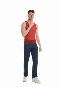 Modello maschile che indossa una canotta rossa trasparente glitterata e jeans blu.