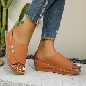 Detail van bruine dames slippers met sleehak, plateauzool en stijlvolle brede band