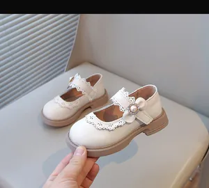 Élégantes chaussures babies blanches pour fillettes avec détail fleur de perle