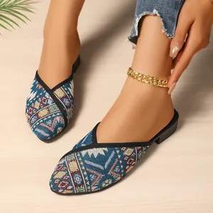Ethno-Mules mit spitzer Kappe und buntem geometrischem Muster für stilvolle Damen.