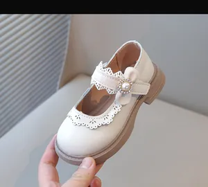 Gros plan de chaussure de princesse blanche pour fille avec boucle de perle et dentelle élégante