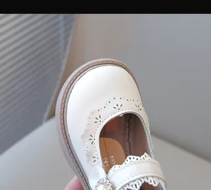 Vue rapprochée de chaussures de princesse blanches pour filles avec dentelle et perle