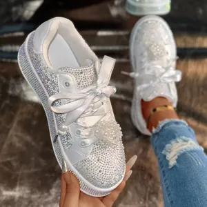 Detailansicht weißer Sneaker mit Strasssteinen, Kristallen und dekorativen Perlen-Schnürsenkeln