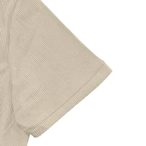 Macro view of the high-quality beige corduroy fabric texture on a men's workwear shirt sleeve