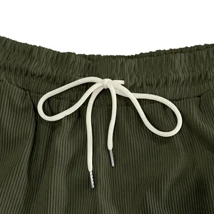 Dettaglio ravvicinato di pantaloncini di velluto a coste verdi con coulisse regolabile