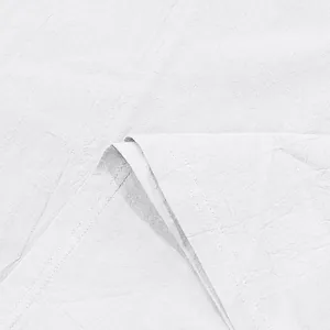 Macro view of high-quality white linen fabric texture with durable double stitching.