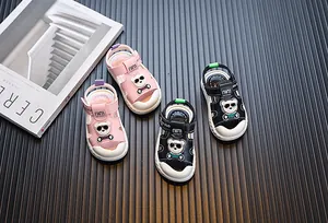 Detailansicht von pinken und schwarzen Kleinkindersandalen mit Bärenmotiv